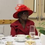 Annual Tea Party 2017 — woman in red hat seated at table