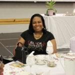 Annual Tea Party 2017 — woman in Black Nurses shirt smiling at table